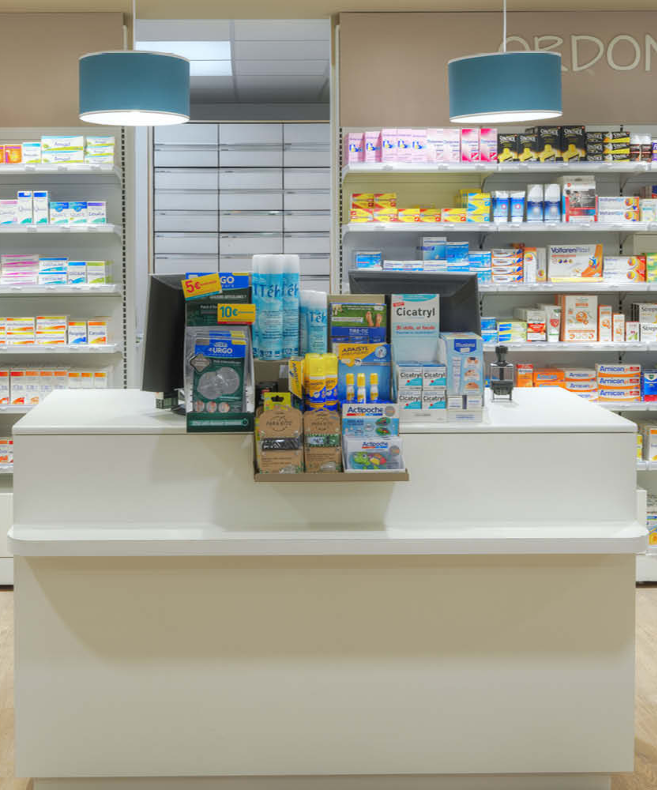 Comptoirs modulaires blancs de la pharmacie Brainoise à Braine, intégrés dans un design lumineux et épuré.