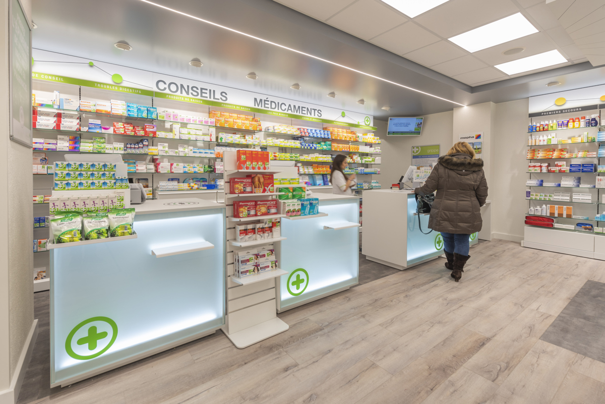 Comptoirs d’accueil modernes — circulation fluide et proximité renforcée entre patients et équipe officinale.