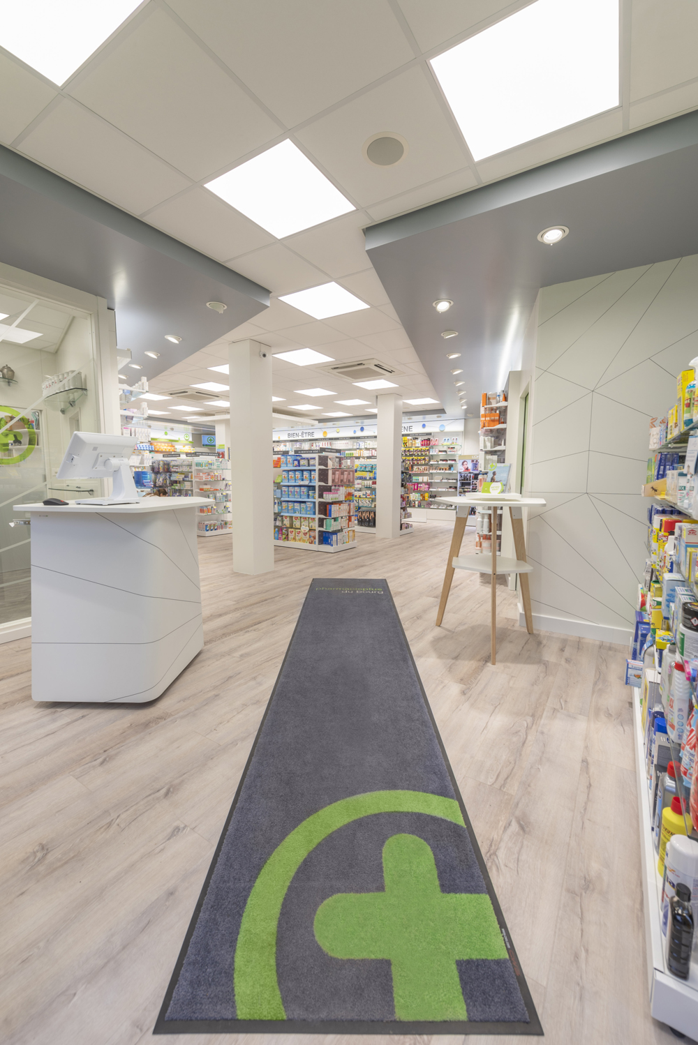 Comptoirs d’accueil modernes — circulation fluide et proximité renforcée entre patients et équipe officinale.