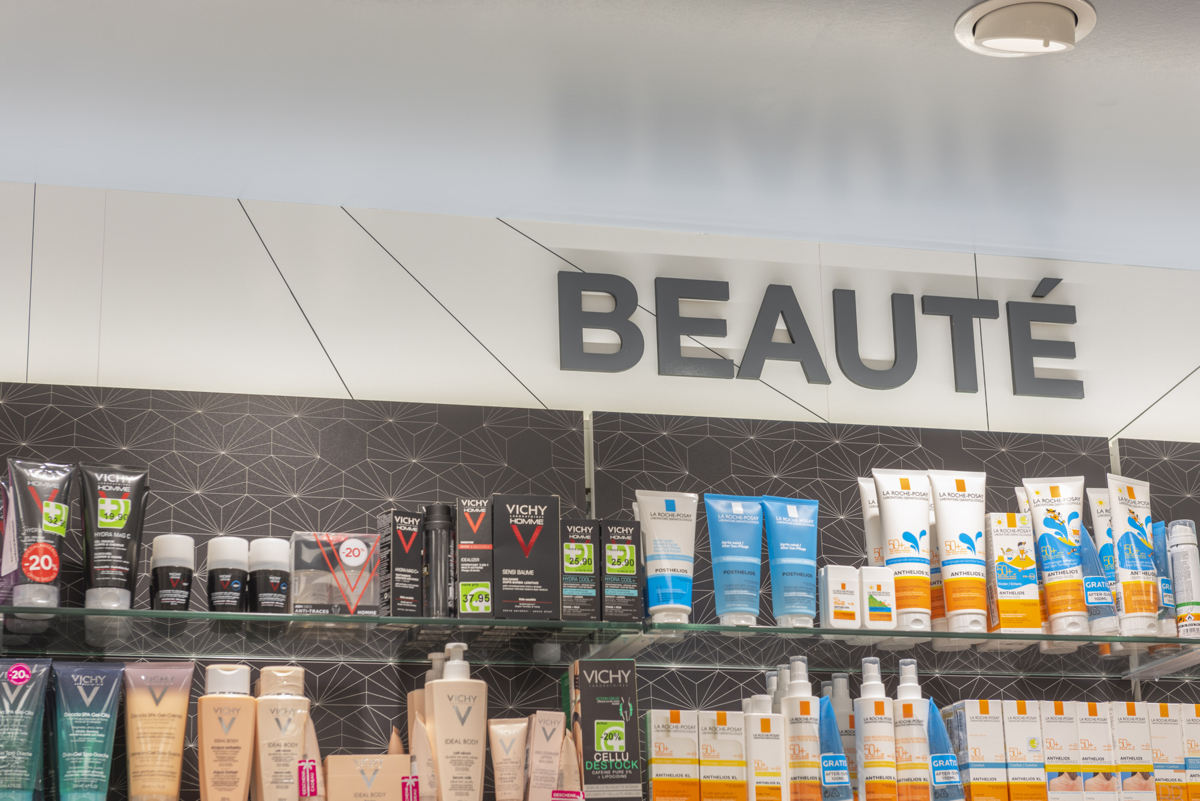 Gros plan sur la signalétique intérieure — design épuré et lisible facilitant le repérage des univers santé et beauté.