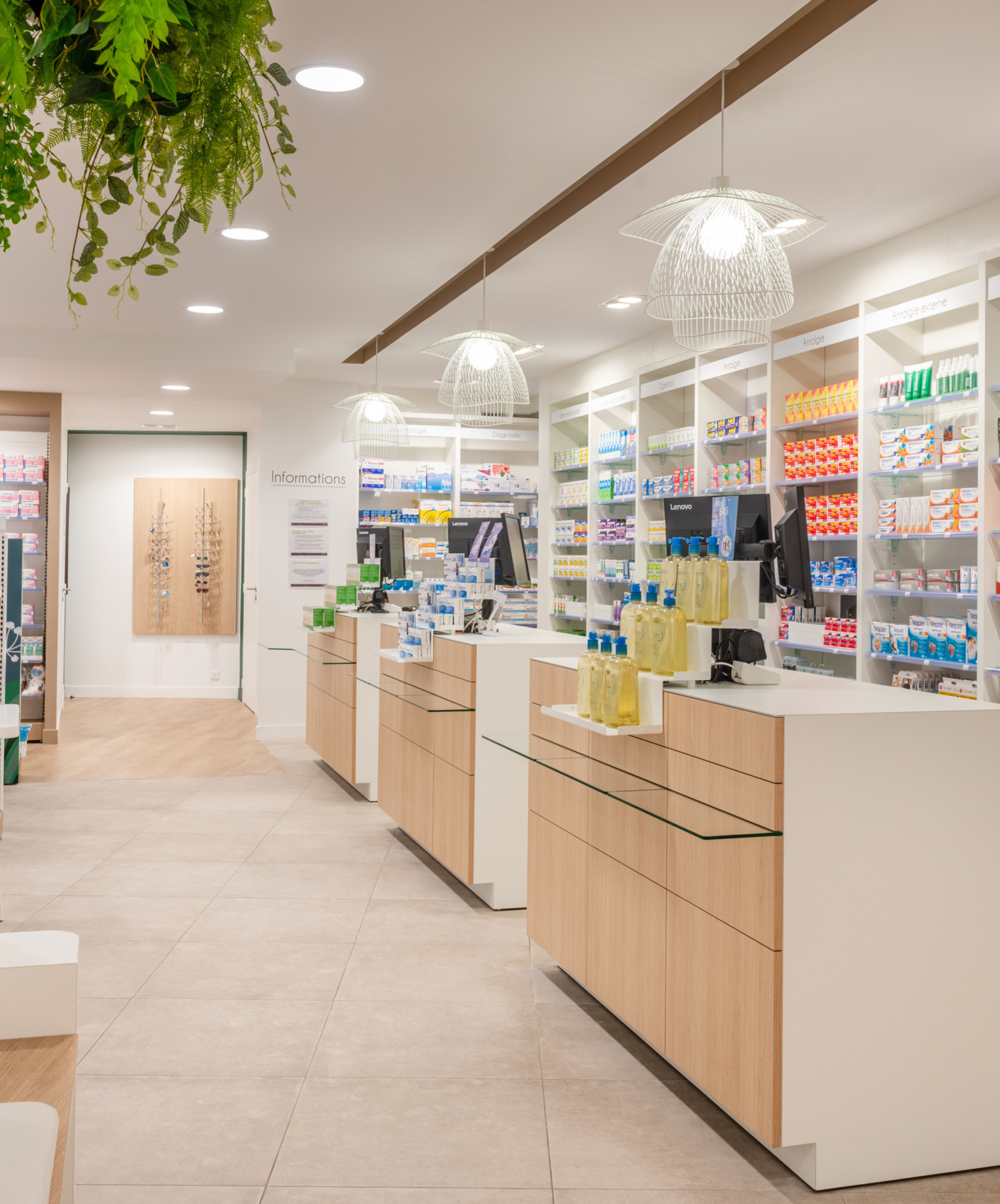 Comptoirs épurés en bois clair et blanc de la Pharmacie des 3 Îles, favorisant un accueil chaleureux et une relation de proximité avec la patientèle.