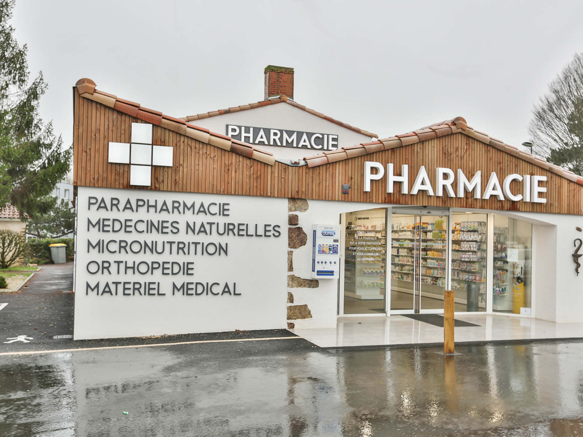 Façade de la Pharmacie Béchieau, mise en valeur par une vitrophanie élégante et des teintes naturelles.