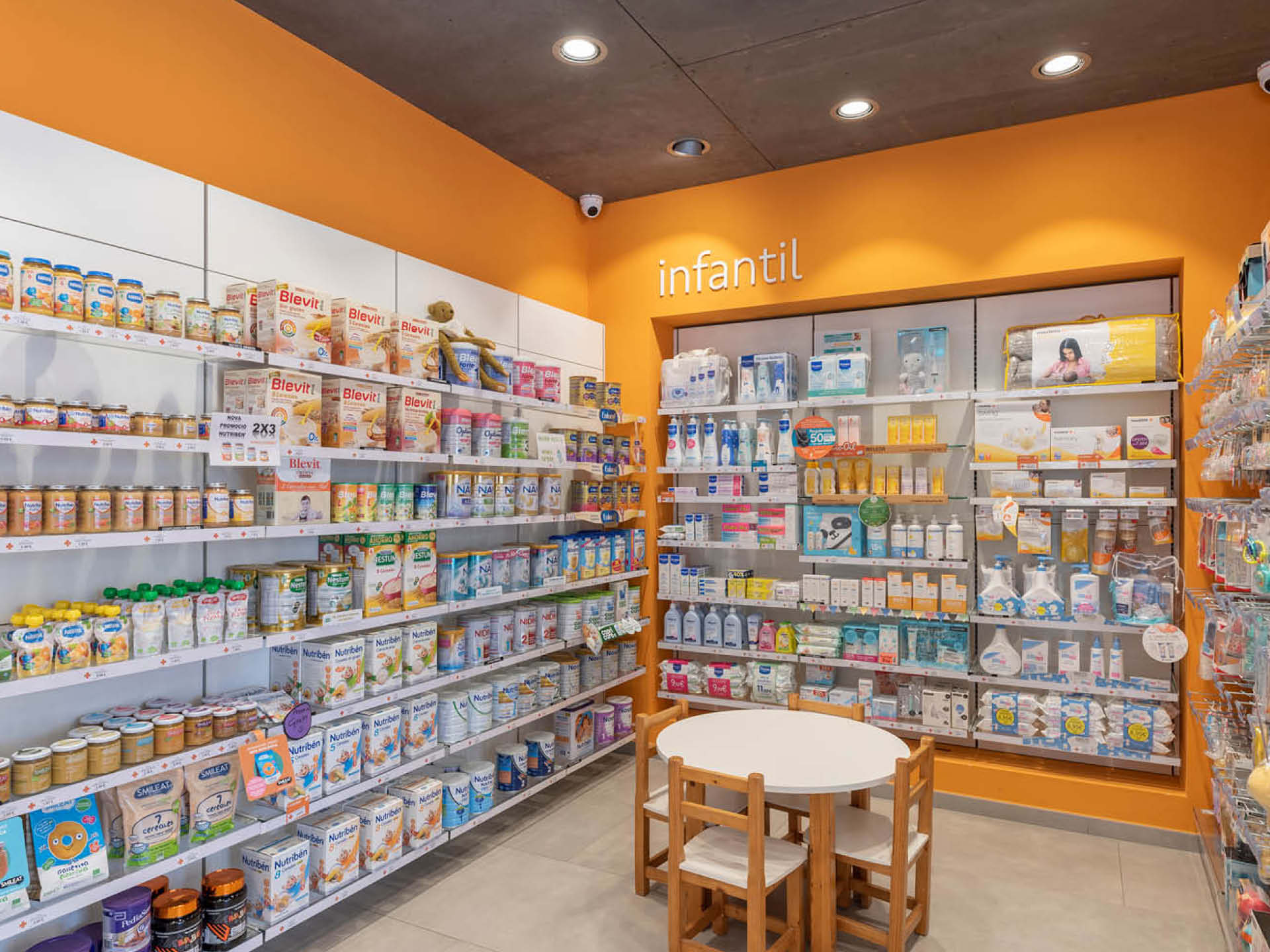 Espace enfant mis en valeur par une touche de couleur orange, intégrée harmonieusement dans l’aménagement global de l’espace de vente.