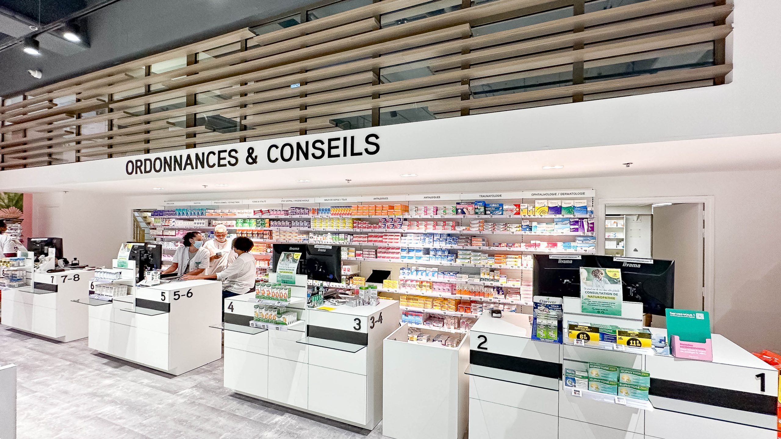 omptoirs de la Pharmacie La Galleria au Lamentin, agencés pour une circulation fluide et équipés d’un système de coupe-file pour optimiser le parcours client.
