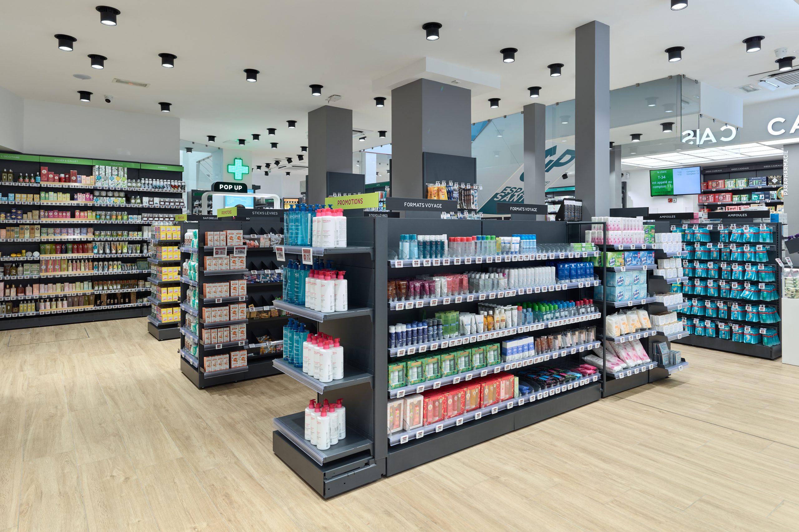 Espace de vente lumineux et moderne de la Pharmacie Carré Opéra, organisé sur deux niveaux pour un parcours client fluide.