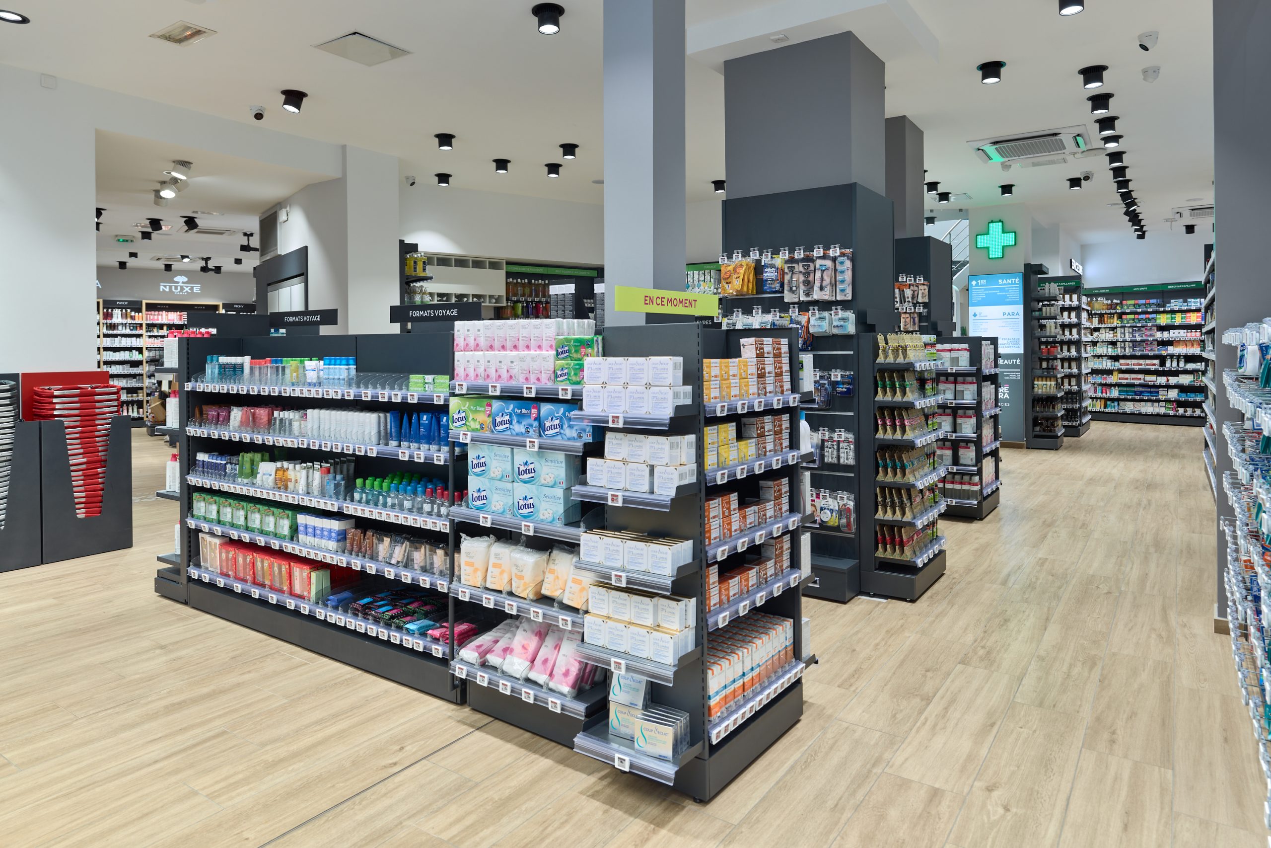 Espace de vente lumineux et moderne de la Pharmacie Carré Opéra, organisé sur deux niveaux pour un parcours client fluide.