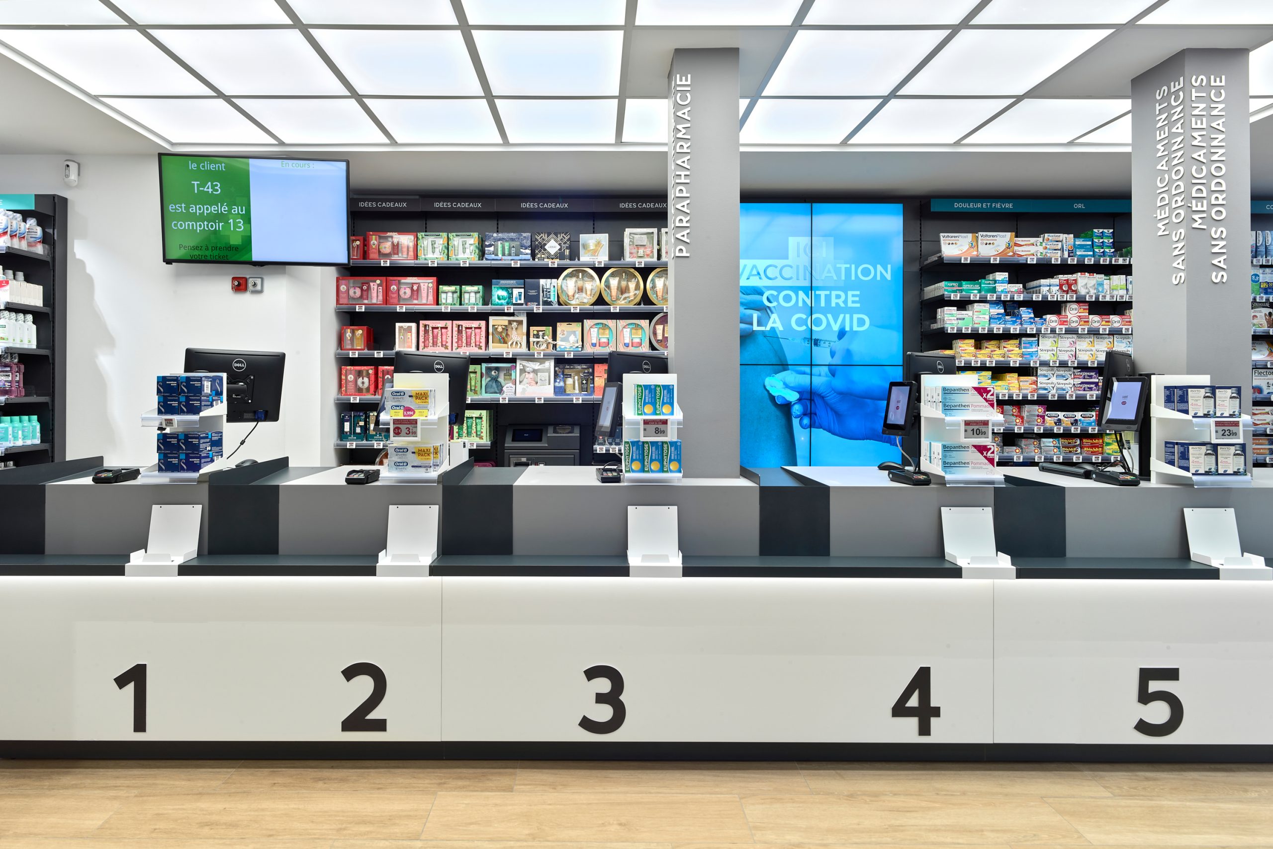 Comptoirs modernes et fonctionnels de la Pharmacie Carré Opéra, optimisant la gestion des flux de clients.