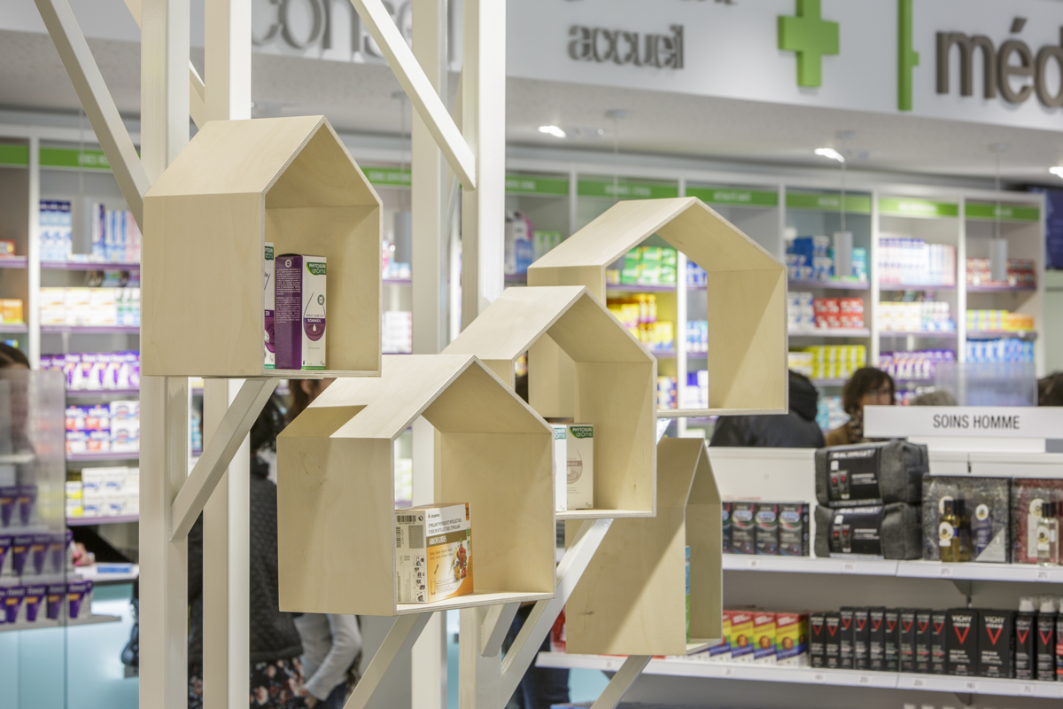 Élément décoration en bois dans la pharmacie pour rappel du logo.
