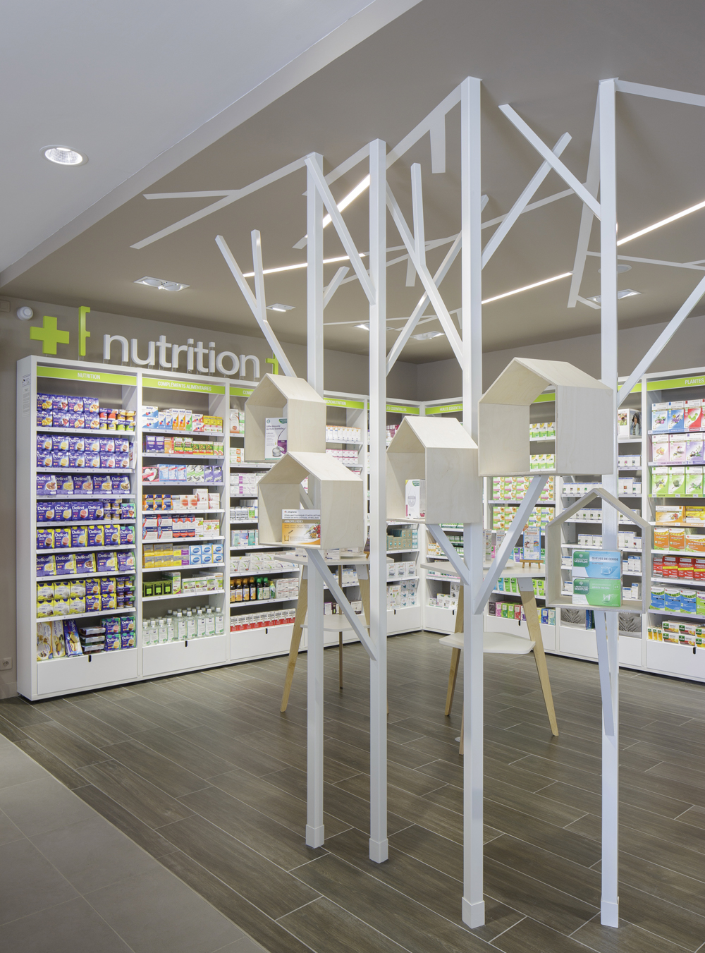 Élément décoration en bois dans la pharmacie pour rappel du logo.