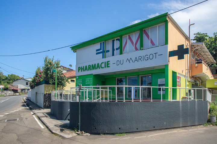 Façade modernisée de la Pharmacie du Marigot en Martinique, avec logo repensé et identité colorée bleu et rouge magenta.
