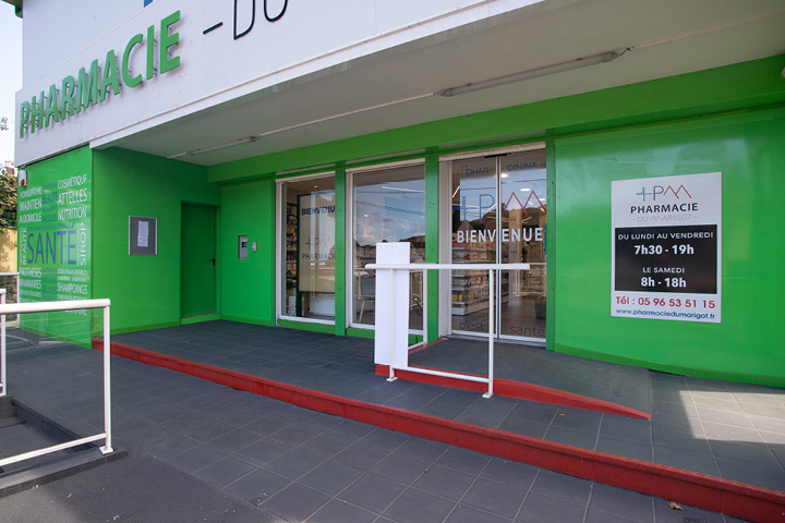 Façade modernisée de la Pharmacie du Marigot en Martinique, avec logo repensé et identité colorée bleu et rouge magenta.