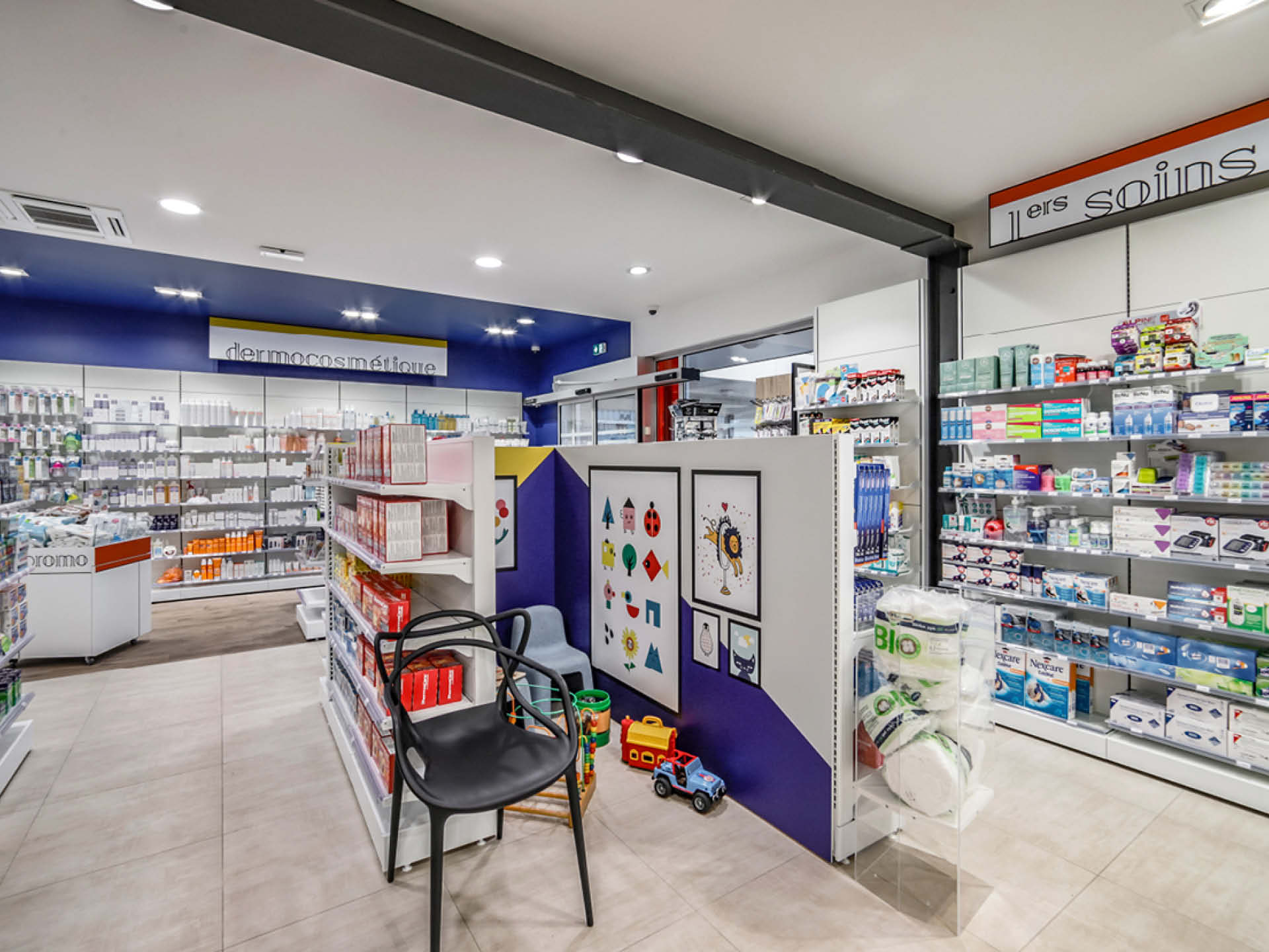 Signalétique intérieure colorée et géométrique, guidant la patientèle vers les différents univers de l’officine.
