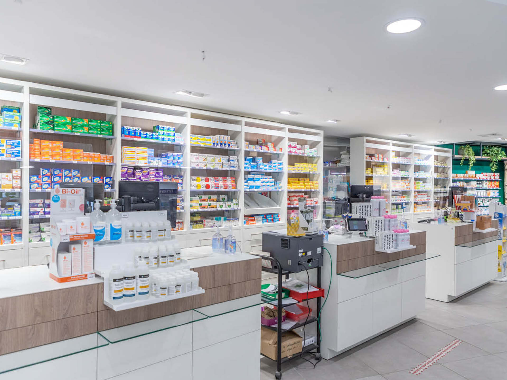 Comptoirs avec mobilier en bois et design ergonomique, intégrant signalétique et optimisant les échanges avec la patientèle