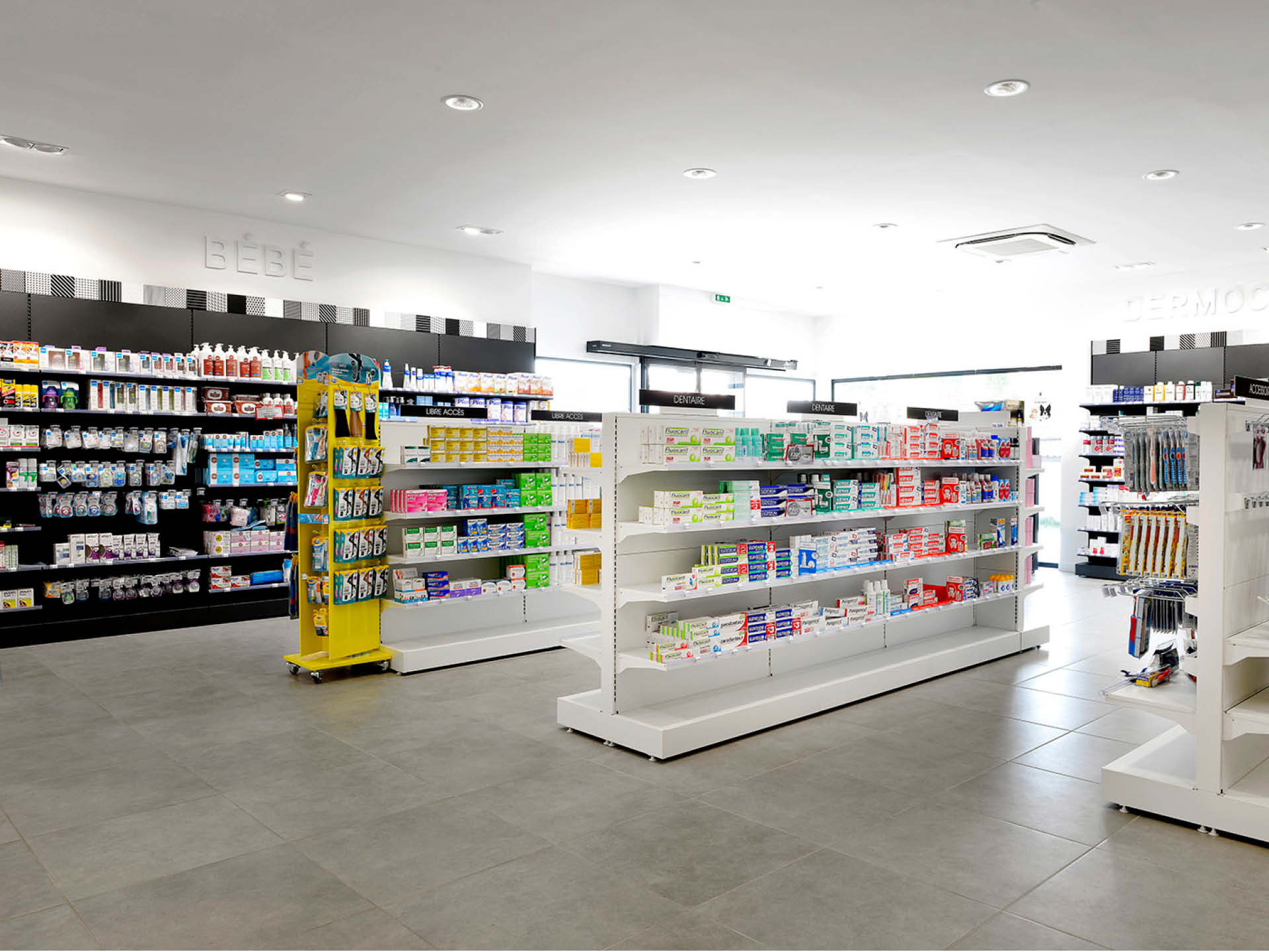 Aménagement intérieur lumineux de la pharmacie des Forges, comptoirs ergonomiques et parcours client fluide.