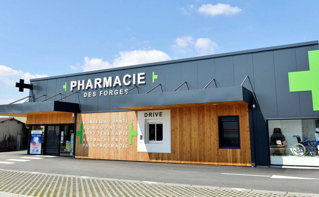 Pharmacie des Forges à Vallet, façade en bardage bois naturel avec drive et signalétique visible depuis la rue.