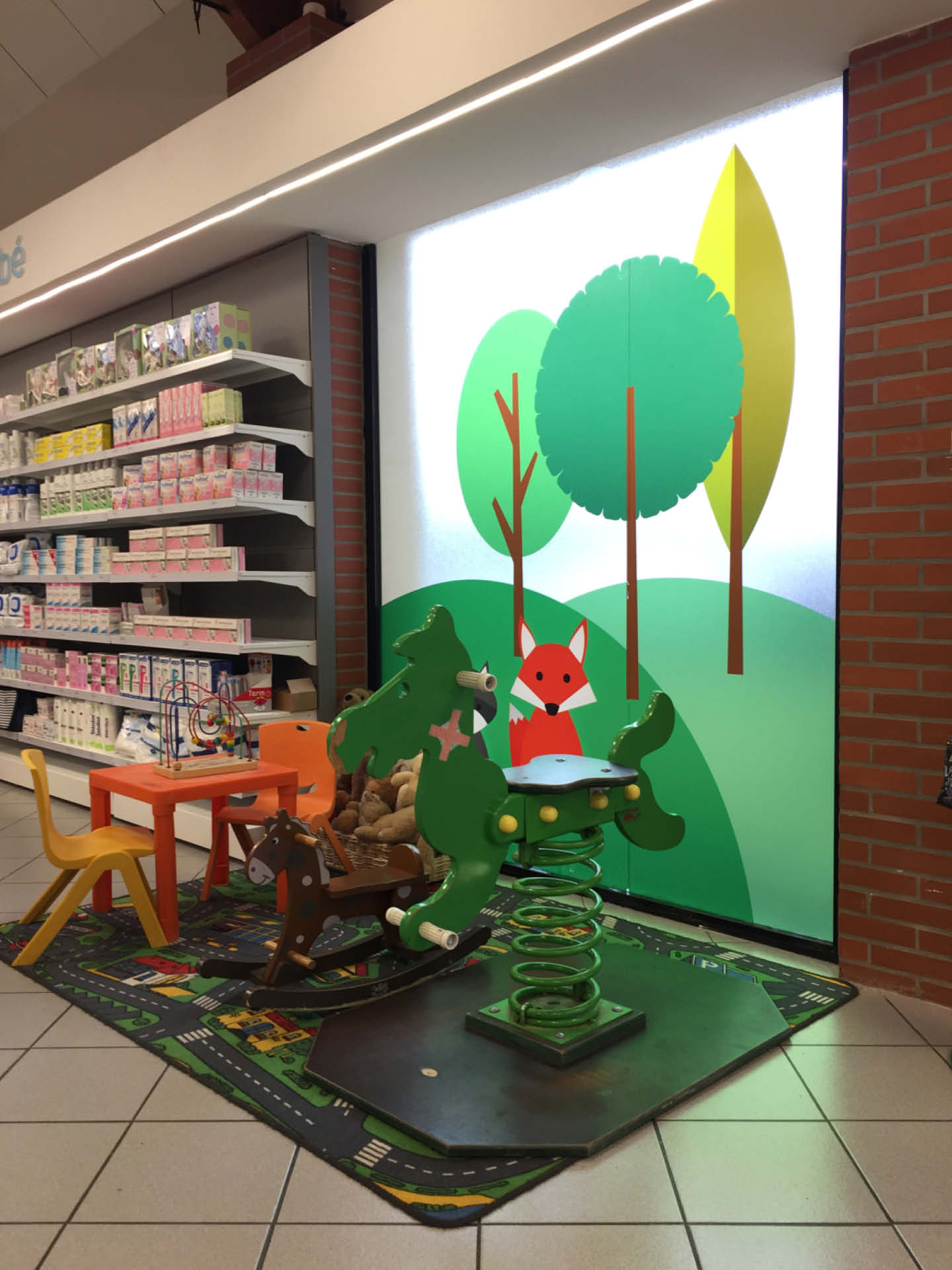 Espace enfant intégré à l’officine — Coin ludique et sécurisé favorisant une expérience d’attente sereine pour les familles.