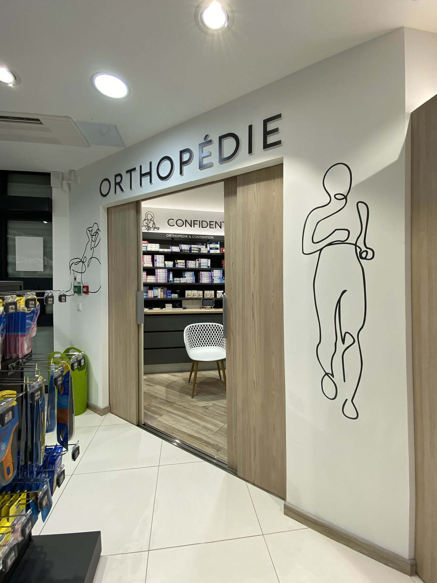 Espace orthopédie avec signalétique boisée et mobilier sur mesure, combinant fonctionnalité, confidentialité et confort pour la patientèle.