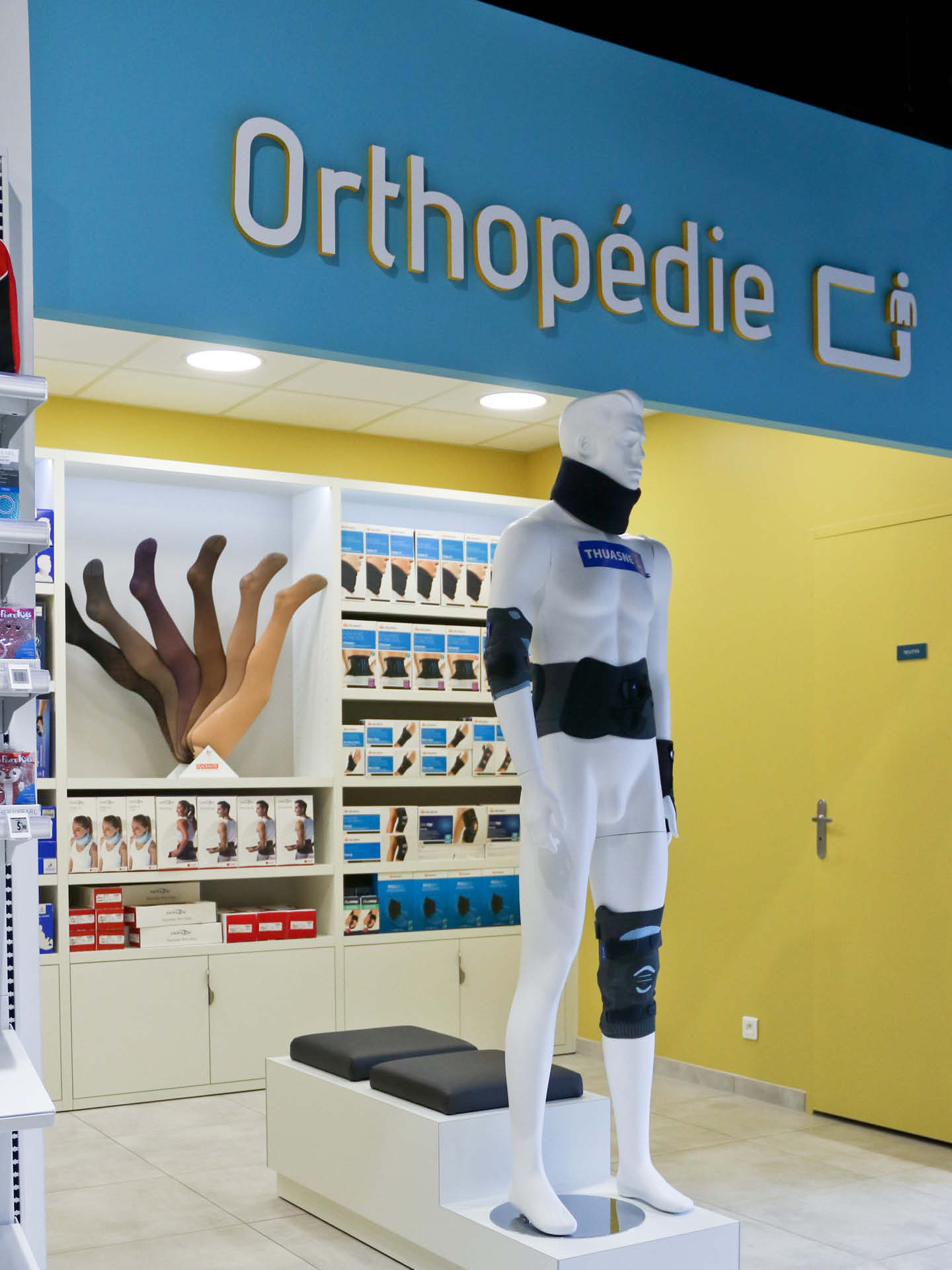 Espace orthopédique aux tonalités bleu et jaune, mettant en avant l’expertise spécifique de la pharmacie.