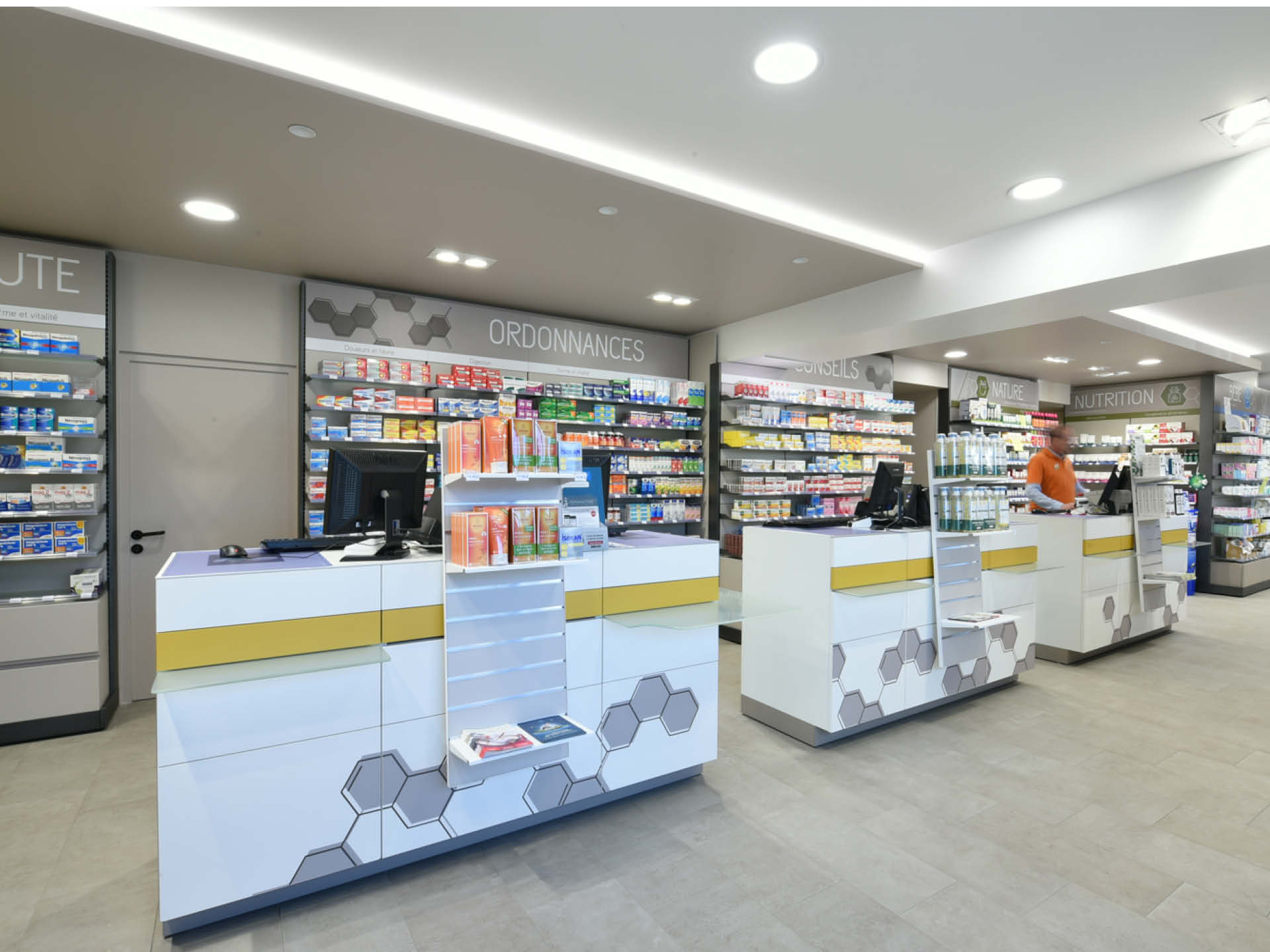 Comptoir jaune vif et design, symbole de l’identité moderne et dynamique de la pharmacie.