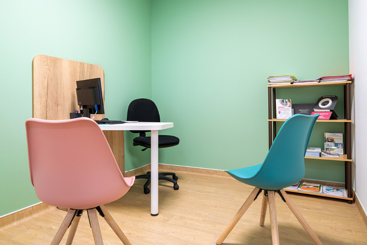 Cabine de confidentialité de la pharmacie à Bar-sur-Aube, aménagée avec des chaises rose et bleue dans un espace lumineux et accueillant.