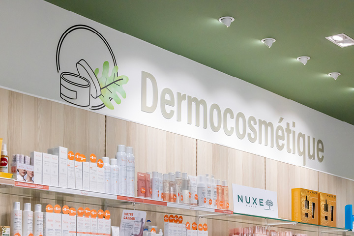 Signalétique claire et cohérente dans la Pharmacie Gare Chêne-Bourg, avec icônes personnalisées inspirées du logo pour identifier les différents espaces santé.