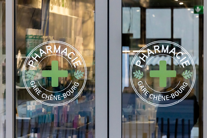 Signalétique claire et cohérente dans la Pharmacie Gare Chêne-Bourg, avec icônes personnalisées inspirées du logo pour identifier les différents espaces santé.