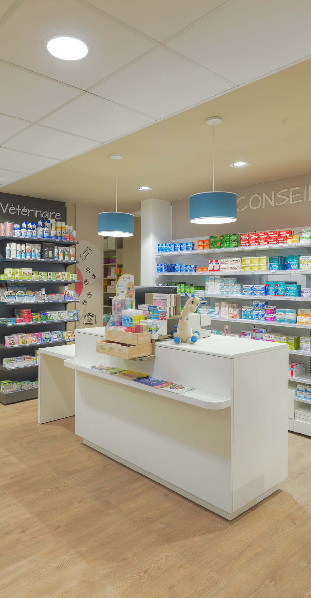 Comptoirs modulaires blancs de la pharmacie Brainoise à Braine, intégrés dans un design lumineux et épuré.