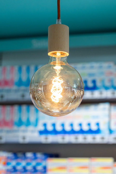 Luminaire moderne et esthétique mettant en valeur les zones clés de la pharmacie et créant une ambiance chaleureuse.
