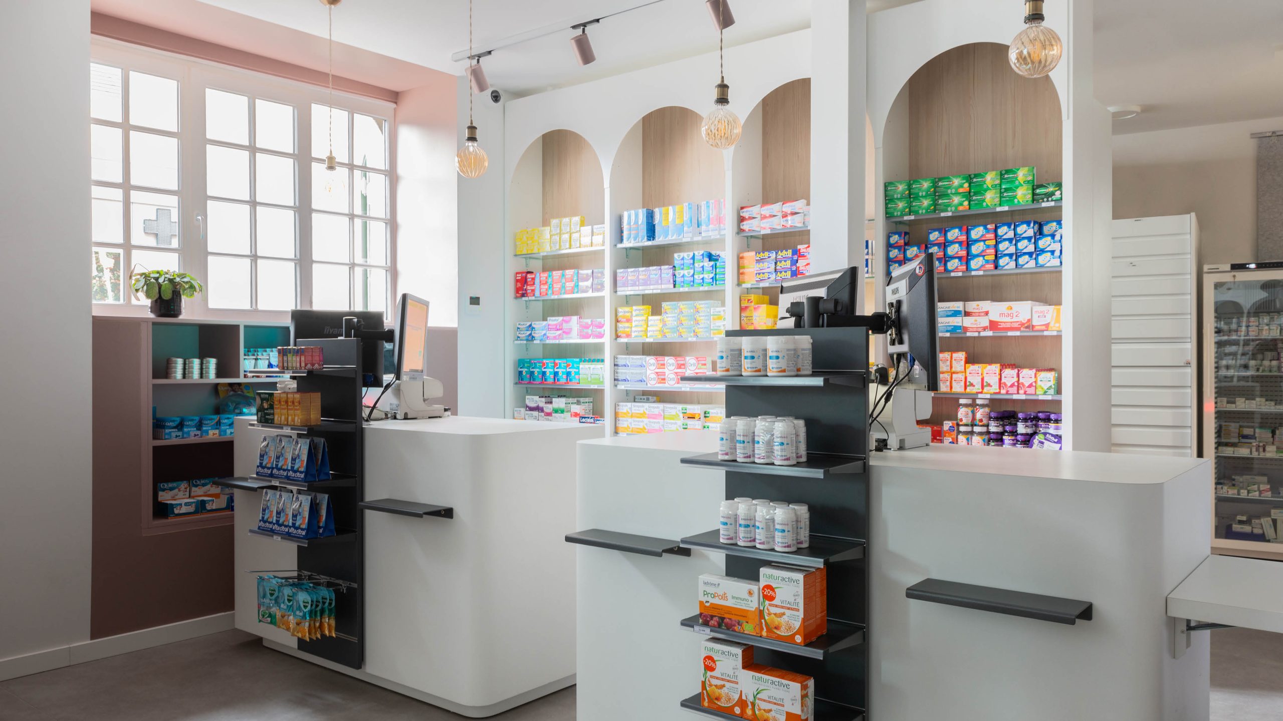 Comptoirs intégrés dans l’espace, fonctionnels et alignés à l’identité visuelle de la pharmacie.