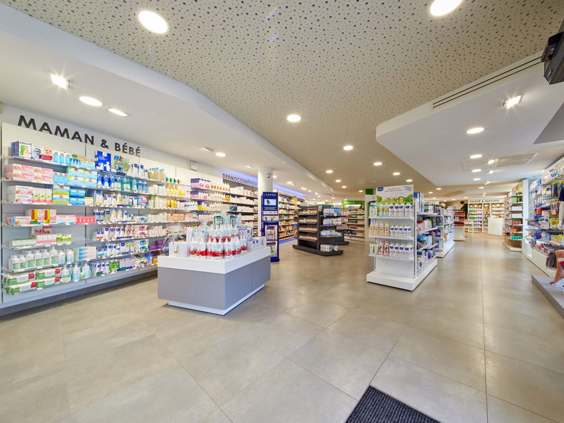 Espace de ventes avec mise en valeur du plafond de la pharmacie via un travail de matière au sein de l'agencement.