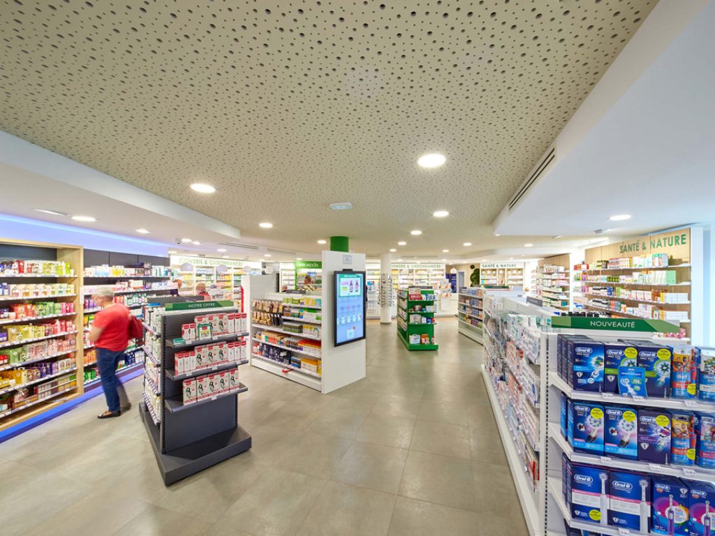 Espace de ventes avec mise en valeur du plafond de la pharmacie via un travail de matière au sein de l'agencement.