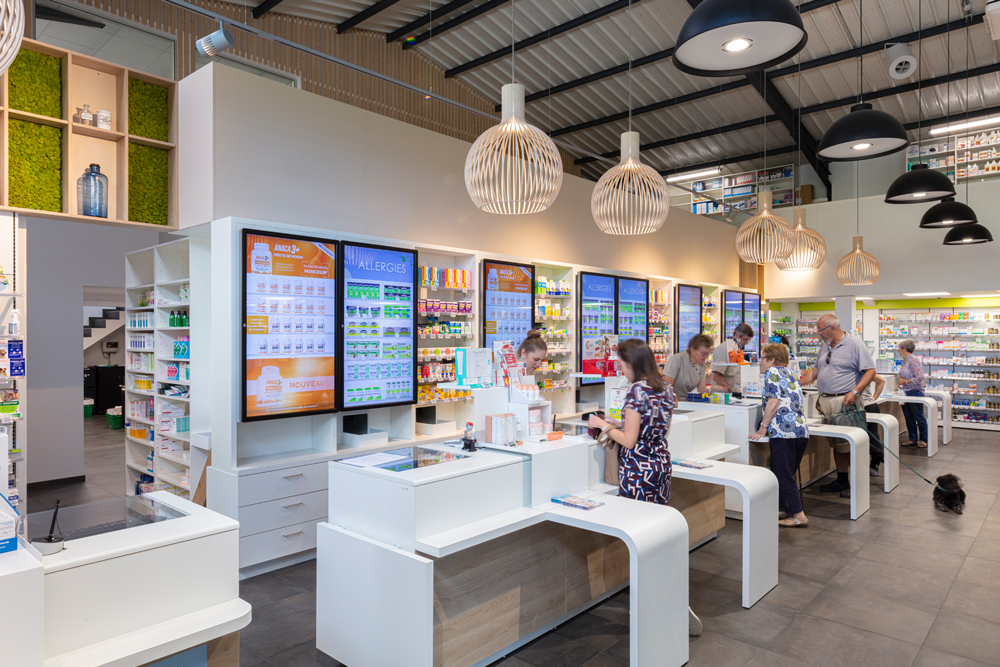 Comptoirs lumineux et fonctionnels intégrant des écrans digitaux pour une expérience client connectée.