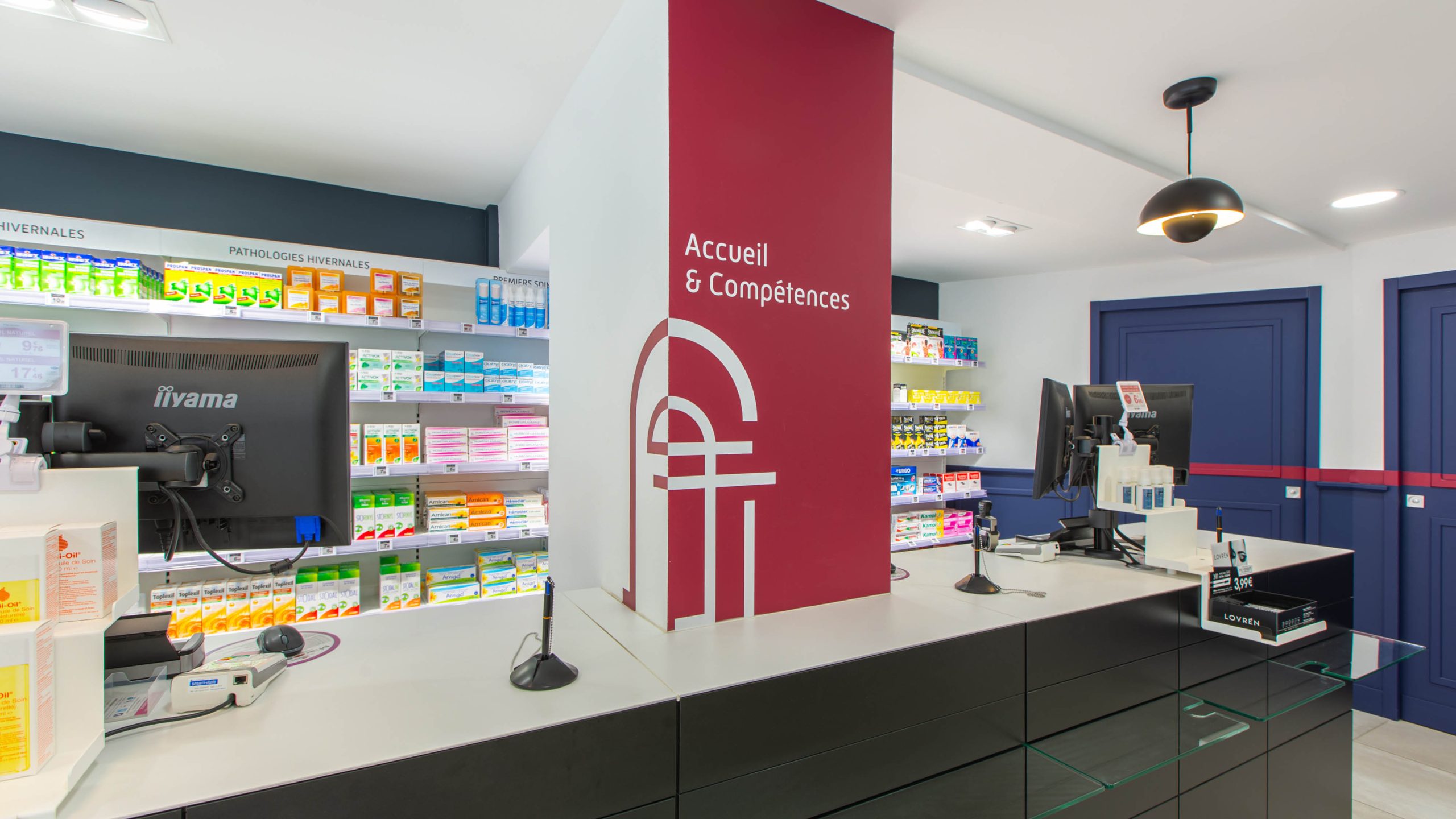 Comptoirs noirs et lustres industriels dans un espace d’attente confortable et chaleureux.