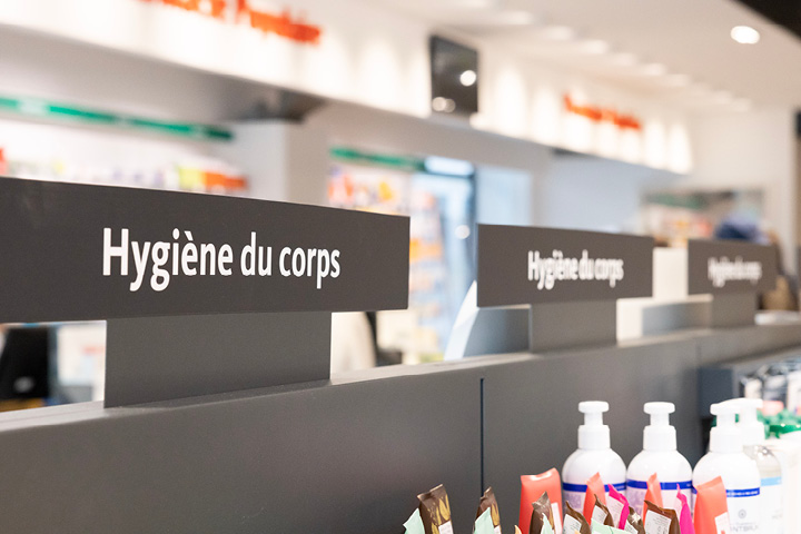 Signalétique intérieure claire de la Pharmacie Populaire guidant les clients dans l’espace de vente.