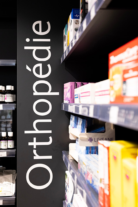 Signalétique intérieure claire de la Pharmacie Populaire guidant les clients dans l’espace de vente.