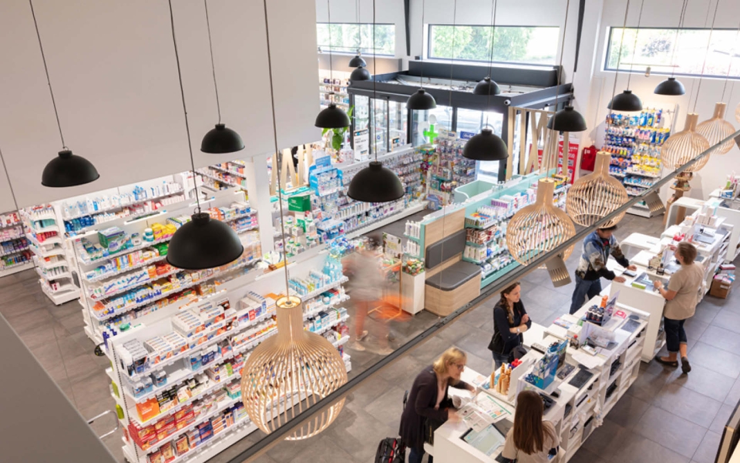 Aménagement d’une pharmacie sécurisée avec comptoirs stratégiquement placés pour limiter les risques de vol.