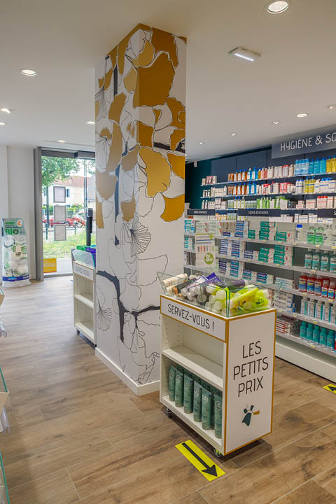 Détails de fleurs naturelles décorant les poteaux de la pharmacie, rappelant l’identité végétale du lieu.