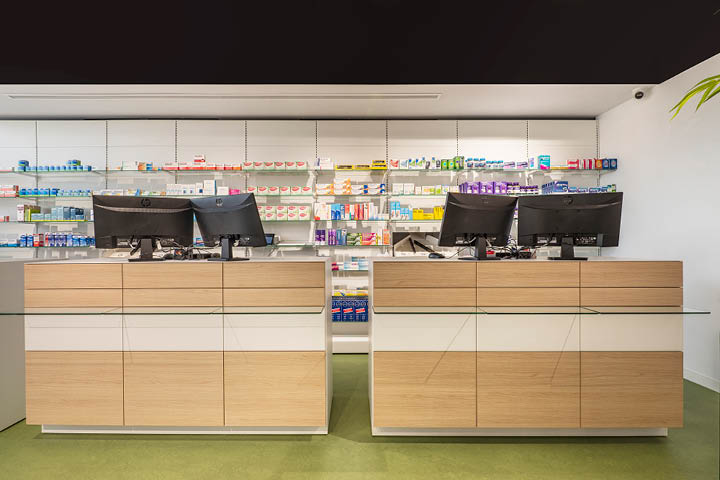 Comptoirs en bois sur-mesure de la Pharmacie Valdecarrizo, intégrés dans l’espace de vente pour un accueil chaleureux et un parcours client optimisé.