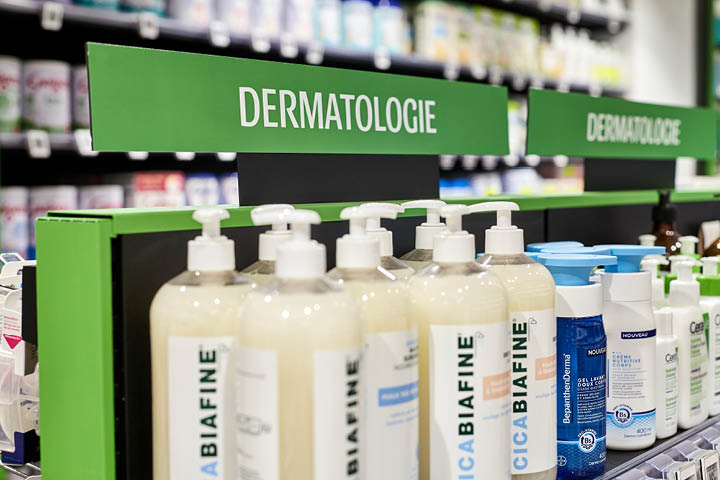 Vue intérieure de la Pharmacie du 20ᵉ montrant le mobilier sur-mesure, les allées fluides et l’agencement optimisé pour un parcours client intuitif.