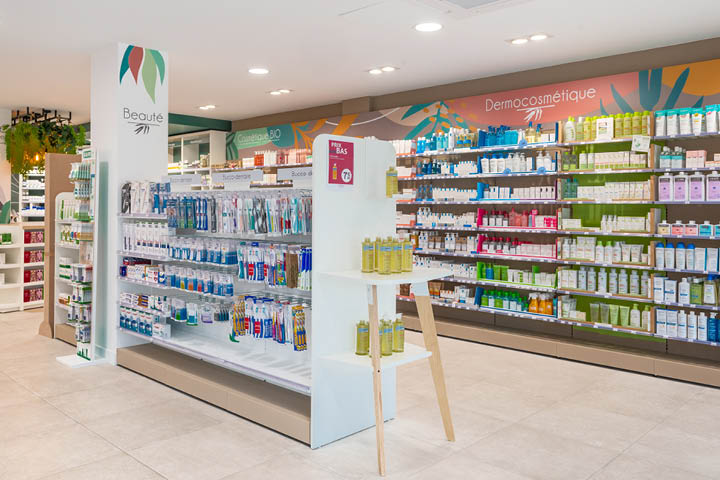 Vue d’ensemble de l’espace de vente lumineux et coloré de la Pharmacie des 3 Îles, organisé par univers santé avec mobilier sur-mesure.