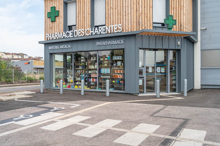 Façade moderne de la Pharmacie des Charentes à Limoges, avec grandes vitrines et tasseaux en bois.