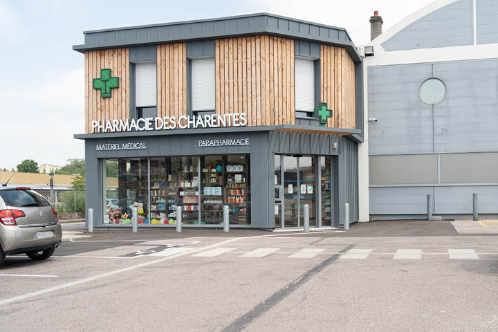 Façade moderne de la Pharmacie des Charentes à Limoges, avec grandes vitrines et tasseaux en bois.