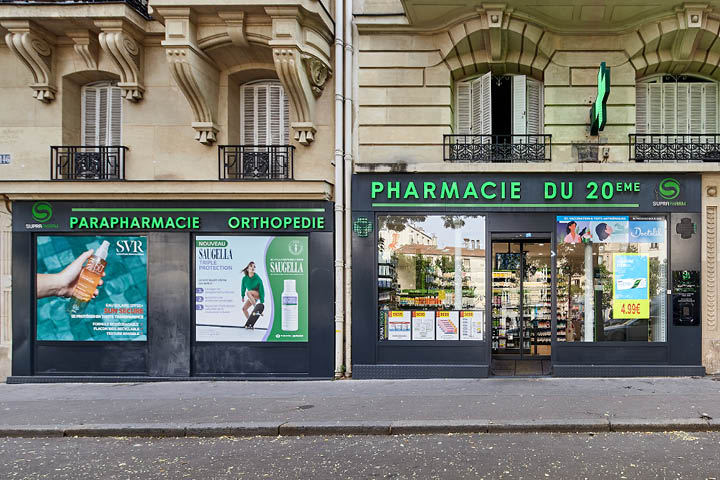 Façade moderne et accueillante de la Pharmacie du 20ᵉ à Paris avec signalétique Suprapharm et grandes vitrines transparentes.