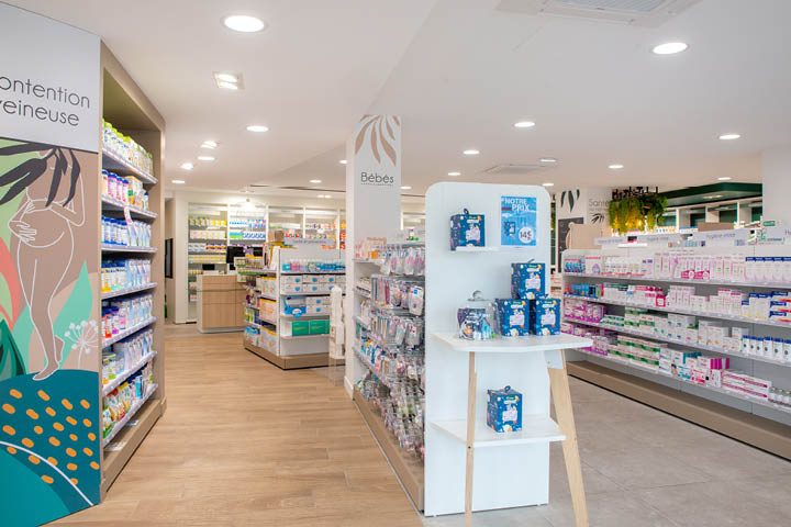 Vue d’ensemble de l’espace de vente lumineux et coloré de la Pharmacie des 3 Îles, organisé par univers santé avec mobilier sur-mesure.
