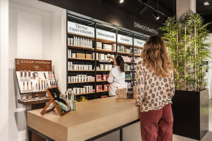 Vue générale de l’espace de vente de la Pharmacie Valdecarrizo avec mobilier sur-mesure, circulation fluide et atmosphère chaleureuse et moderne.