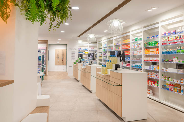 Comptoirs épurés en bois clair et blanc de la Pharmacie des 3 Îles, favorisant un accueil chaleureux et une relation de proximité avec la patientèle.