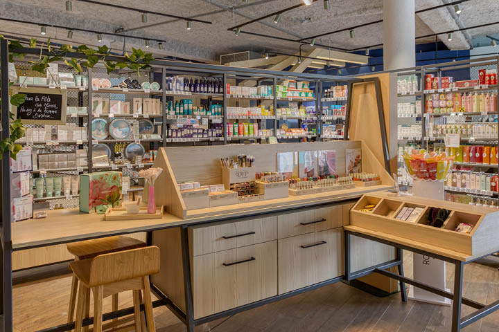 Corner santé naturelle avec linéaires THOR en bois, végétalisation murale et luminaires en fibres naturelles.