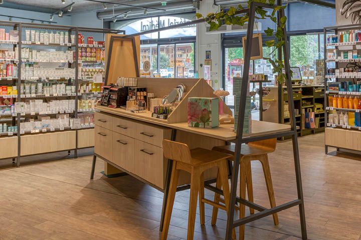 Corner santé naturelle avec linéaires THOR en bois, végétalisation murale et luminaires en fibres naturelles.