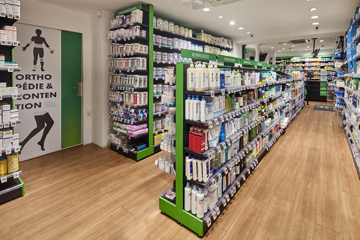 Vue intérieure de la Pharmacie du 20ᵉ montrant le mobilier sur-mesure, les allées fluides et l’agencement optimisé pour un parcours client intuitif.