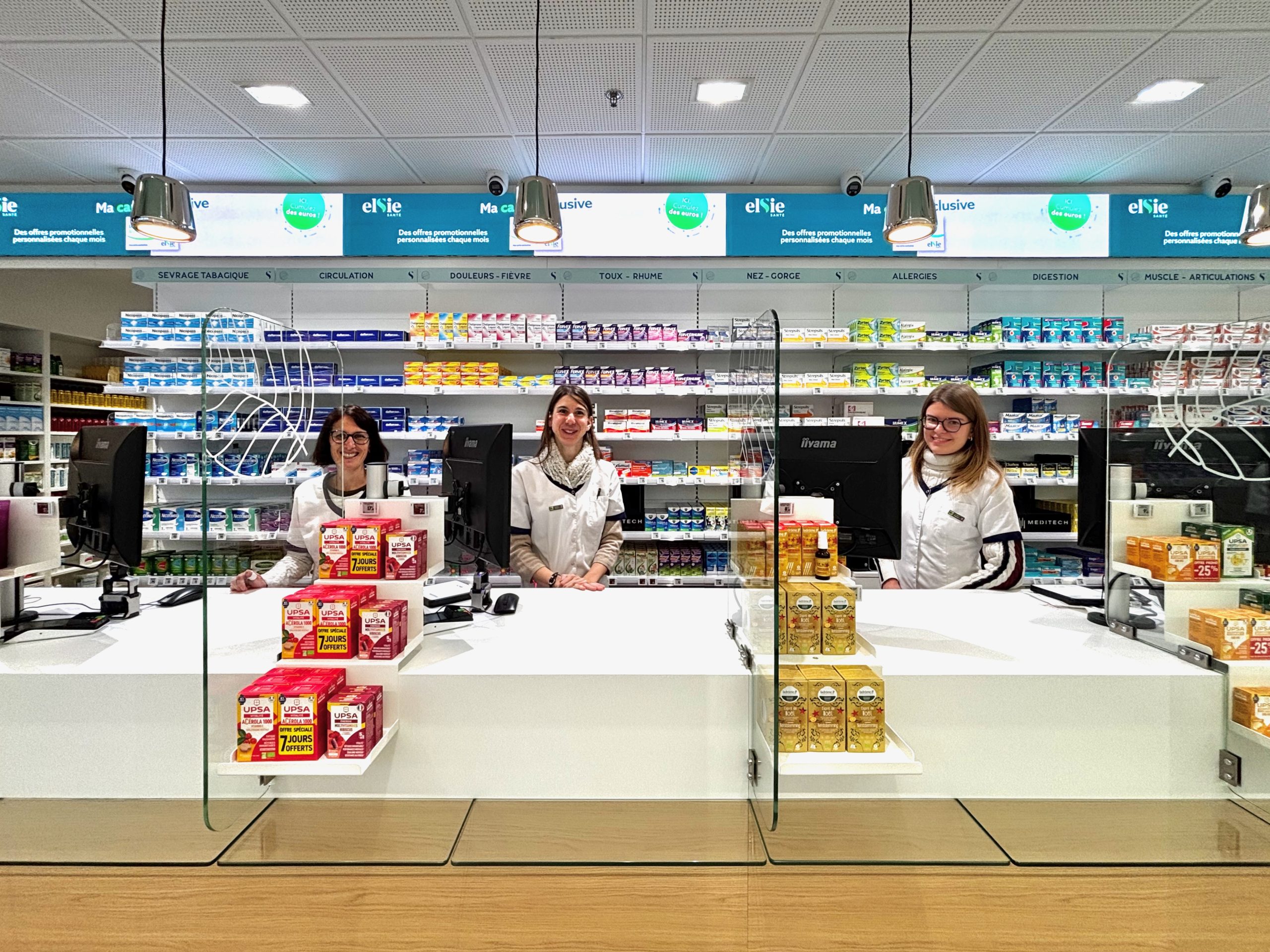 Photo des équipes derrière comptoirs dans la pharmacie des Erlen.